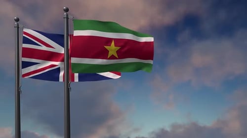Flags of United Kingdom and Suriname Waving Against Cloudy Sky