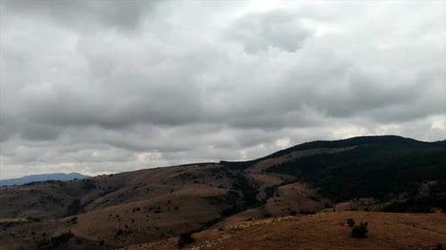 Dron aéreo con hiperlapso de cadena montañosa y nubes de lluvia.