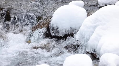 Flussbach im Winterschneewald in den Bergen