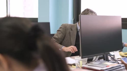 Man Reviews Documents at Office Desk