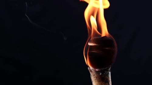 Burning Torch with Bright Flame on Black Background