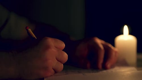 Cinematic Man Writing By Single Candle Light