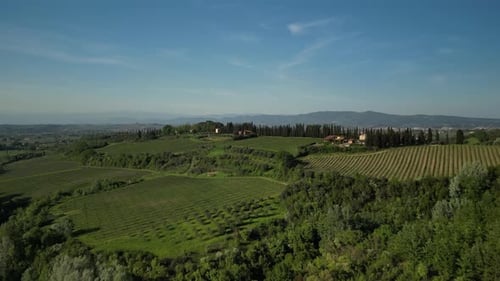 Aerial View of Green Field with Trees Houses Mountains Showing Beauty