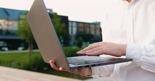 Manos masculinas escribiendo en el teclado de una computadora portátil, manos de hombre de negocios caucásico escribiendo en una computadora portátil, en línea