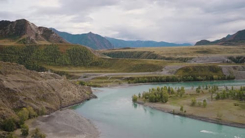 Turquoise Waters Winding Through a Stunning Valley Surrounded By Towering Mountains and Vibrant
