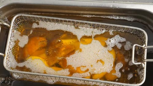 Golden Potatoes Cooking in Deep Fryer