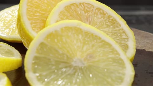 Close up of freshly cut lemon slices on the board. Yellow tropical fruit