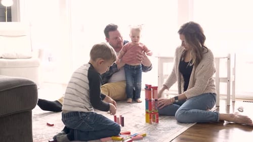 Family plays with toy blocks together in home