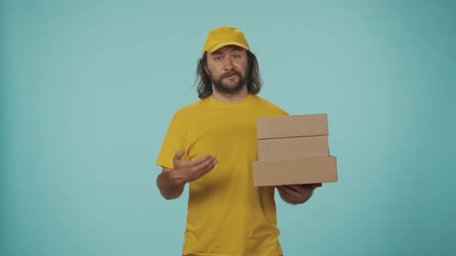 Delivery Man in Uniform Holding a Stack of Postal Boxes and Showing a Make a Call Gesture Isolated