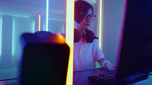 Gamer Focused on Computer with Neon Lights