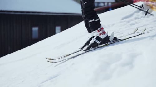 Slow motion shot of person in yellow jacket, skiing down a ski run.