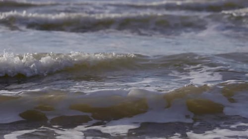 Sea waves rushing at the beach. Slow Motion Ocean White water Wave surf crashing. Medium shot.