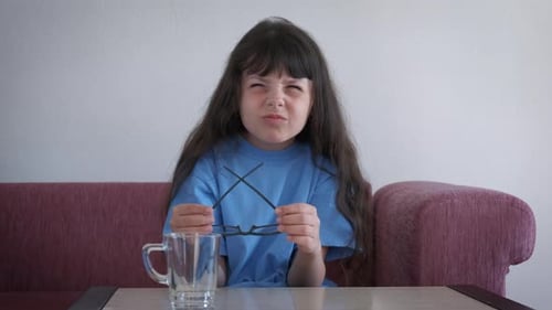 Upset Young Girl Holding Glasses Indoors