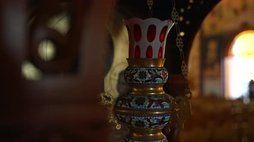 Close up shot of candle stand near the frame in the museum. Gold plated candle holder