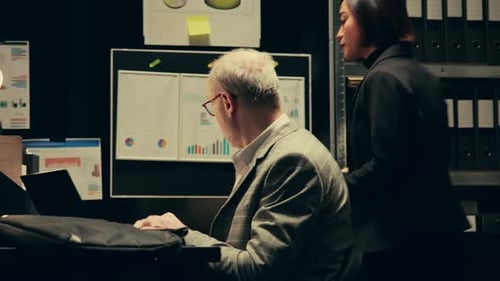 Colleagues Discussing Data at a Laptop in Office