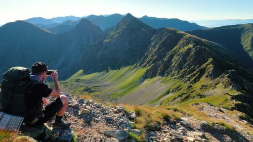 Man Takes Pictures of the Mountains on His Phone While Hiking in the Alps Mountains Trail