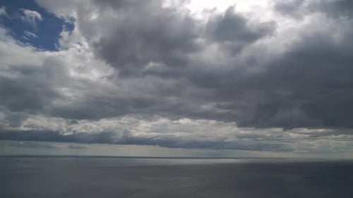 Timelapse Fluffy Cumulus Clouds Moving in Bright Sunset Sky Over Calm Sea Abstract Aerial Nature