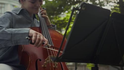 Inspired Female Musician Playing Cello Outdoors in Park