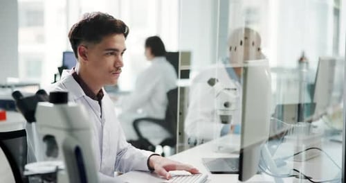 Scientist Typing at Computer in Modern Laboratory