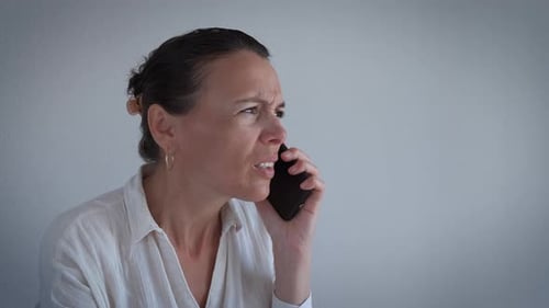 Upset Woman Talking on Mobile Phone