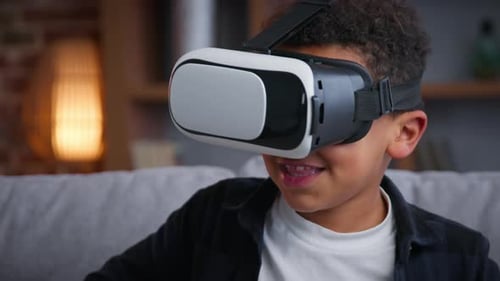 Excited Boy Wearing VR Headset Sitting on Couch