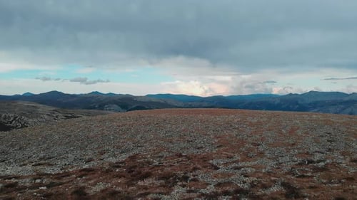 Aerial View Flying Over Rocky Tundra Landscape and Mountain Range Media
