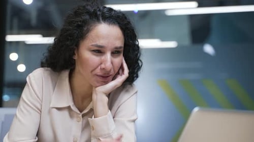 Overworked businesswoman feels tired and wants to sleep working on laptop sitting at workplace