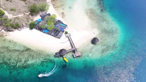 Kelor Island nature reserve in Komodo. Pier on small tropical beach with coral reef. Indonesia
