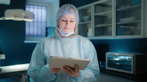 Adult Doctor Uses Tablet in Operating Room