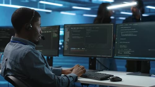 Man Using Headphones Mic to Talk with Manager Supervising Data Center