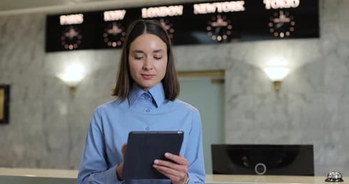 Young Woman Receptionist Using Tablet in Hotel Professional Woman on Digital Tech for Hospitality