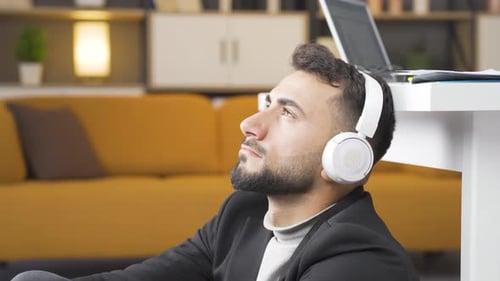 Man Listening to Music with Headphones Indoors