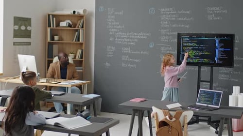 Junges Mädchen hält vor der Klasse einen Vortrag über Programmieren