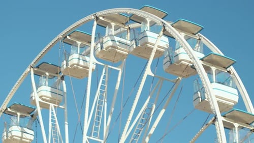 Large Ferris Wheel With Bright Cabins at the Amusement Park During Clear Blue Skies