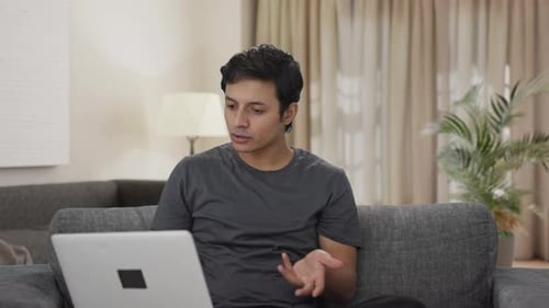 Young Adult Man Video Conferencing At Home