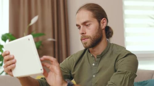 Young Adult Man Uses Tablet Device at Home