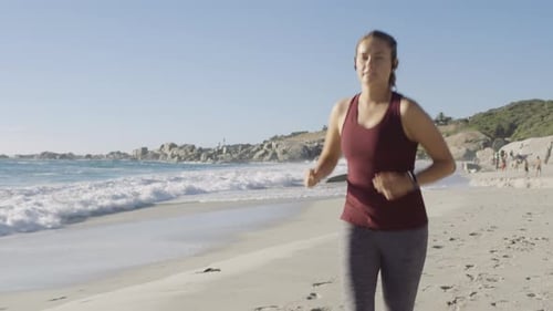Running on beach, fitness and woman with headphones for music or podcast