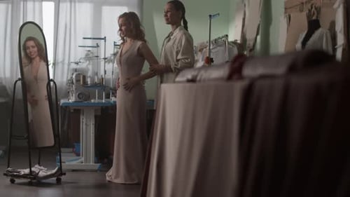 Cheerful Female Trying New Dress in Dressmaker Shop