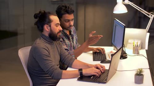 Deadline, Technology and People Concept - Programmers with Computers Working Together Late