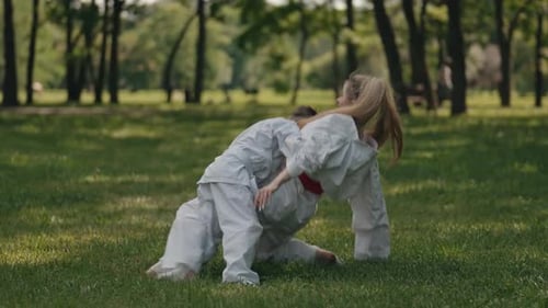 Woman and Child Sparring Martial Arts in Park