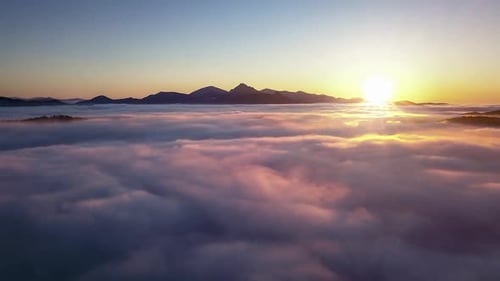 Golden Sunrise Over Dreamy Clouds and Mountains
