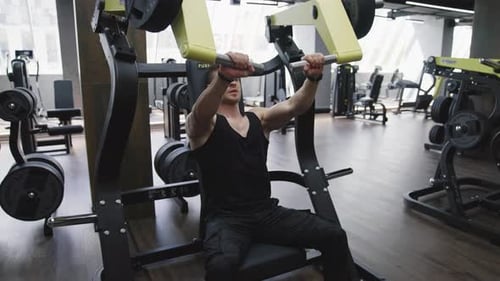 Fit and muscular athlete actively training in the modern gym