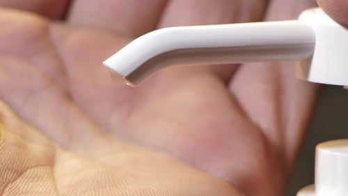 Ein Mann desinfiziert seine Handflächen mit speziellen antibakteriellen Gelees. Nahaufnahme, kein Gesicht