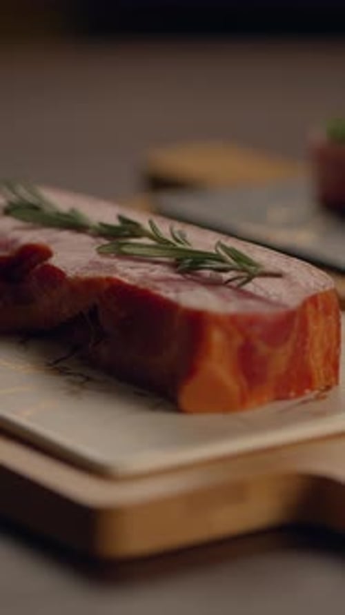 Delicious Fresh Cut Steak with Aromatic Rosemary Served on a Rustic Wooden Board