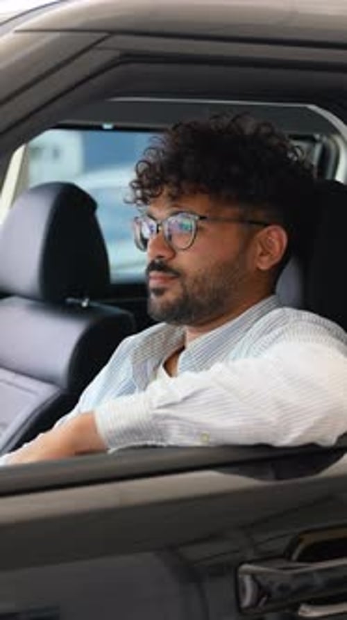 Happy Arabian Man Showing New Car Key While Sitting in Vehicle