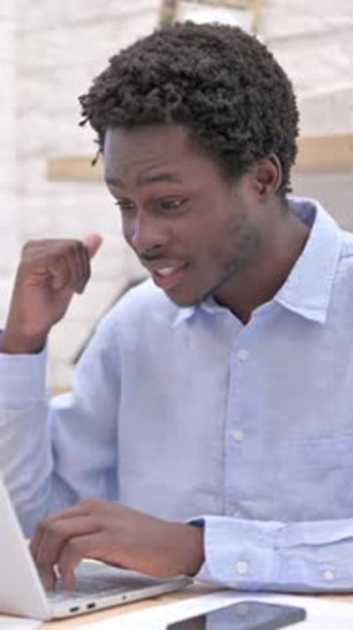 Young Man Video Conferencing at Desk Waving Hand