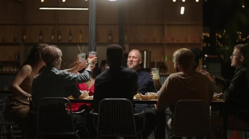 Friends Toasting at Outdoor Restaurant at Night