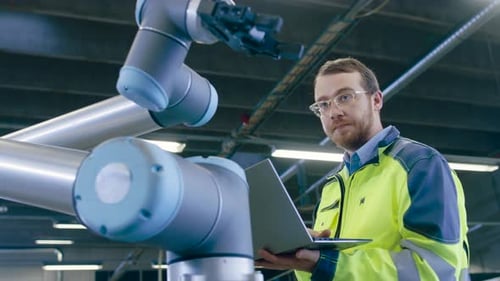 Close-up Shot of the Industrial Engineer Wearing Classes and Hard Hat Connects Two Components He De
