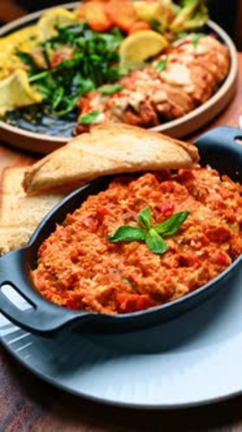 Plato tradicional de shakshuka con pan tostado en sartén negra.