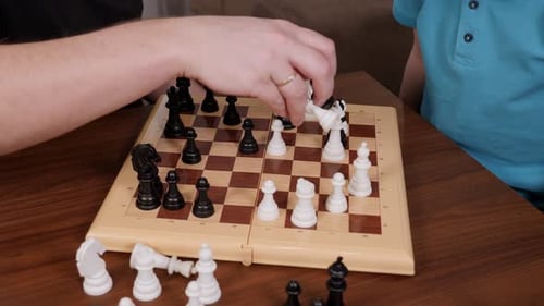 Closeup of a Happy Father Playing Chess with His Little Son at Home